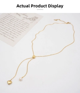 Detail of adjustable golden Y-necklace with heart pendant and pearl on minimalist chain