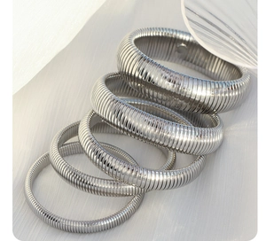 Macro detail of silver stainless steel spring bracelets with various thickness and texture