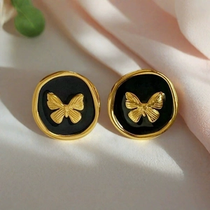 Detailed close-up of retro enamel round stud earrings with golden butterfly on black base