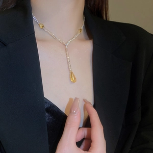Gros plan d'un collier en Y doré avec trois zircons jaunes en forme de goutte