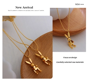 Detail view of a golden mechanical rabbit pendant with LUCK engraving on bead chain