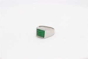 Macro shot of silver titanium ring featuring a square emerald green gemstone inlay