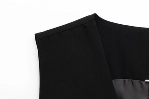 Detailed view of the V-neck tailoring and smooth lining on the black suit vest