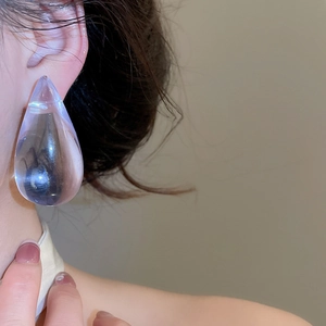 Detailed macro view of transparent lilac acrylic water drop earrings showing sleek texture