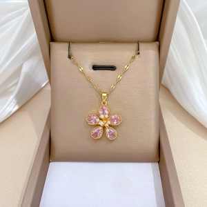 Pink five-leaf flower necklace with gold titanium chain displayed on white silk