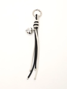 Detail of hand-woven black and white leather keychain with silver heart charm and metal clip