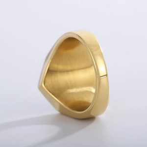 Detailed view of polished gold hexagonal signet ring with brushed metal texture and finish