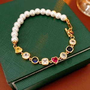 Nahaufnahme von Vintage Gold-Perlenarmband mit buntem Herz-Zirkon in einer grünen Box