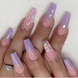 Close-up of long coffin purple gradient press-on nails with butterfly and rhinestones