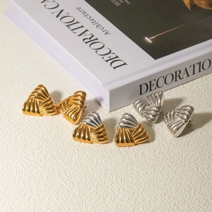 Detailed view of geometric triangle earrings with braided texture in gold and silver