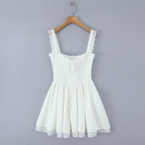 Close-up of lace trim and ribbon bow detail on white ruffle strap mini dress