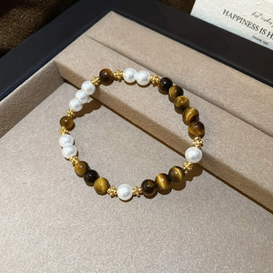 Detail of beaded bracelet with tiger eye stones and white pearls in a jewelry gift box