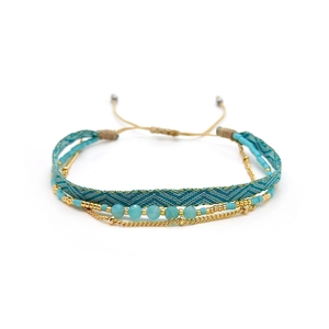 Detail view of multi-layer Miyuki bead bracelet with blue woven strap and gold beads