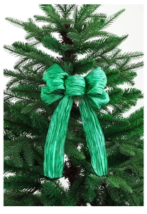 Close-up of a glittering green Christmas bow with metallic finish on a tree branch