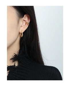 Detailed close-up of textured gold ear cuff and earring set on model with stylish finish