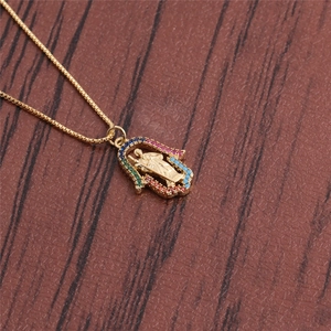 Gold Hamsa Hand necklace with colorful cubic zirconia and portrait relief on wood