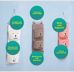 Detail of multi-color wall-hanging fabric storage bags with animal patterns and wood bar