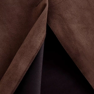Gros plan du tissu en daim marron foncé montrant les coutures fines et la doublure