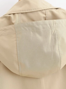 Detailed close-up of khaki hooded jacket showing twill fabric texture and stitching