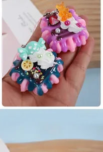 Close-up of mini resin strawberry cream cakes with bears for keychains and bag decor