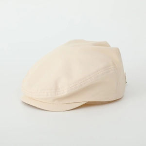 Detail of beige cotton beret showing reinforced triple stitching on the peak