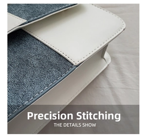 Detail shot of precision stitching on a white PU leather and blue denim patchwork bag