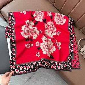 Detail of red square shawl with white peony flower print and leopard pattern borders