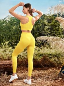 Outdoor model shot of bright yellow seamless breathable yoga top and high-waist leggings set
