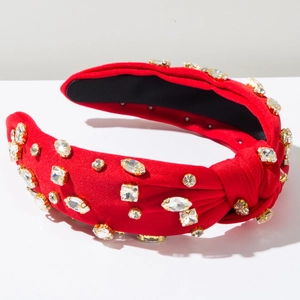Détail du serre-tête rouge en tissu avec cristaux scintillants et large design noué