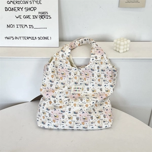 Detail showing quilted fabric texture and cartoon dog print on the beige tote bag