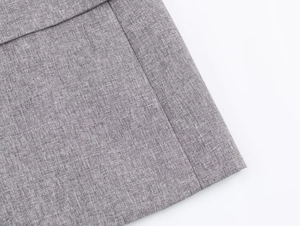 Close-up of grey herringbone fabric texture and stitching detail on the skirt suit set