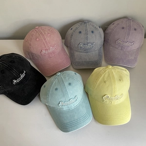 Flat lay of vintage washed cotton baseball caps in six diverse colors with patch embroidery