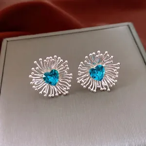 Silver earrings with blue heart zircon and radiating flower design in luxury style