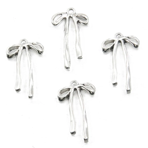 Detailed view of silver bow-shaped alloy pendants for DIY necklace and bracelet crafting
