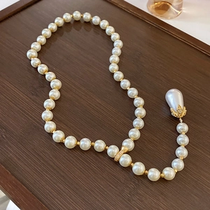 Double-layered pearl necklace with golden flower spacers and a large waterdrop pendant