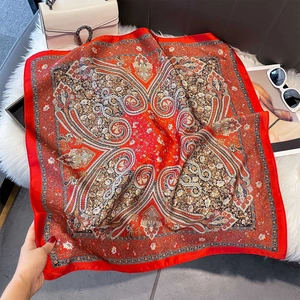 Detail of red paisley silk-like square scarf on white faux fur background