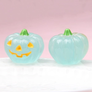Detailed view of luminous blue glass pumpkins with glowing yellow jack-o'-lantern faces