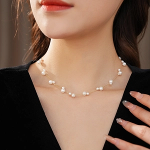 Vue détaillée du collier double rang en or avec grappes de perles blanches élégantes