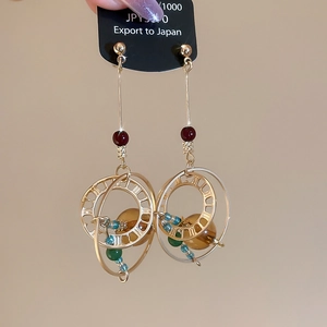 Macro detail of vintage gold crystal earrings with colorful beads and amber drops