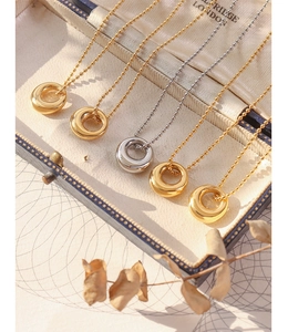 Detailed view of polished oval pendant necklaces in a jewelry box with bead chains