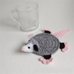 Macro detail of handmade crochet turtle coaster showing knit texture and grey yarn patterns