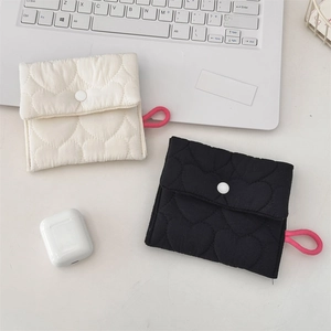 Detailed view of quilted cotton sanitary pouch with heart patterns in white and black colors