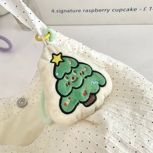 Detail of embroidered Christmas tree plush pendant on a white canvas bag with clips
