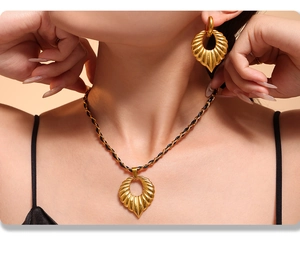 Close-up of 18k gold-plated heart jewelry set worn by a model with a black chain