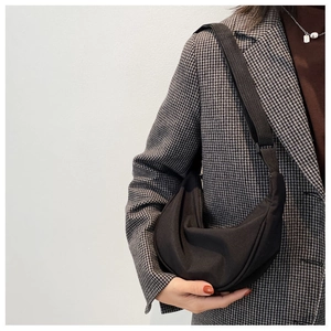 Fashionable black nylon crescent crossbody bag styled with a grey houndstooth blazer