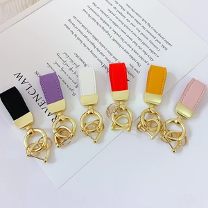 Colorful leather and gold metal keychains in black purple white red orange and pink colors