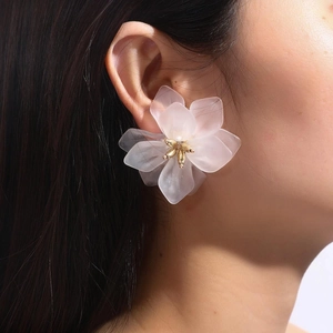 Detail of white matte flower earring on model showing translucent petals and gold center
