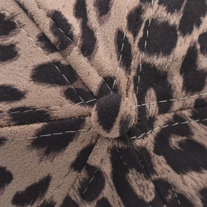 Dettaglio ravvicinato del berretto leopardato con texture in finta pelle scamosciata