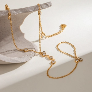 Elegant gold plated stainless steel bracelet with zircon crystals on a stone display