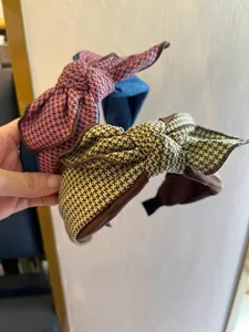 Détail de serre-têtes larges avec nœuds en pied-de-poule rose et tissu texturé vert